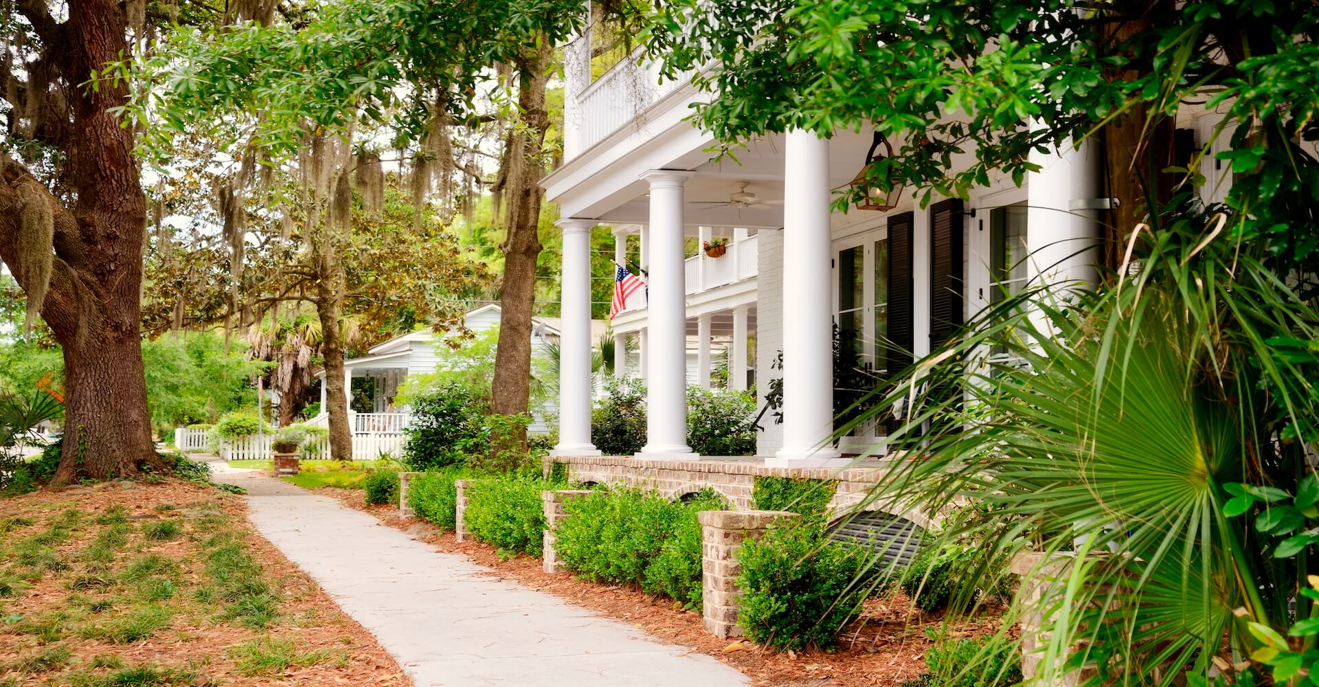 side walk in front of home with white columns