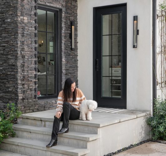 woman and dog sitting on a front porch