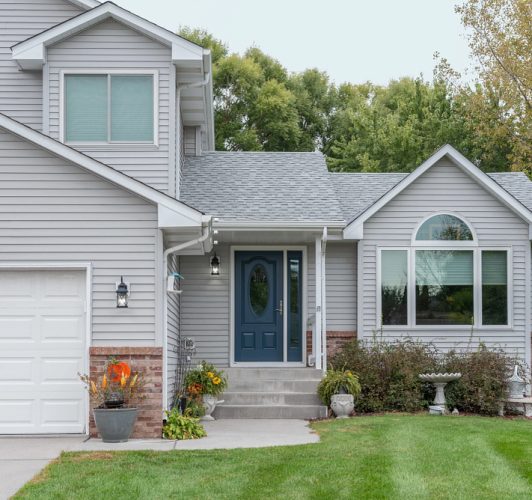 front porch of gray home with blue door