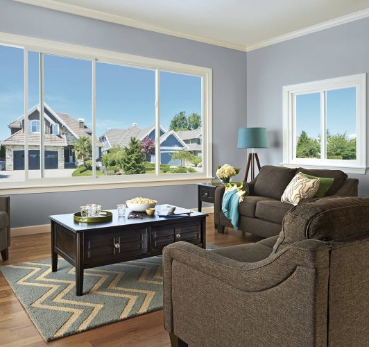 living room with brown furniture and white windows
