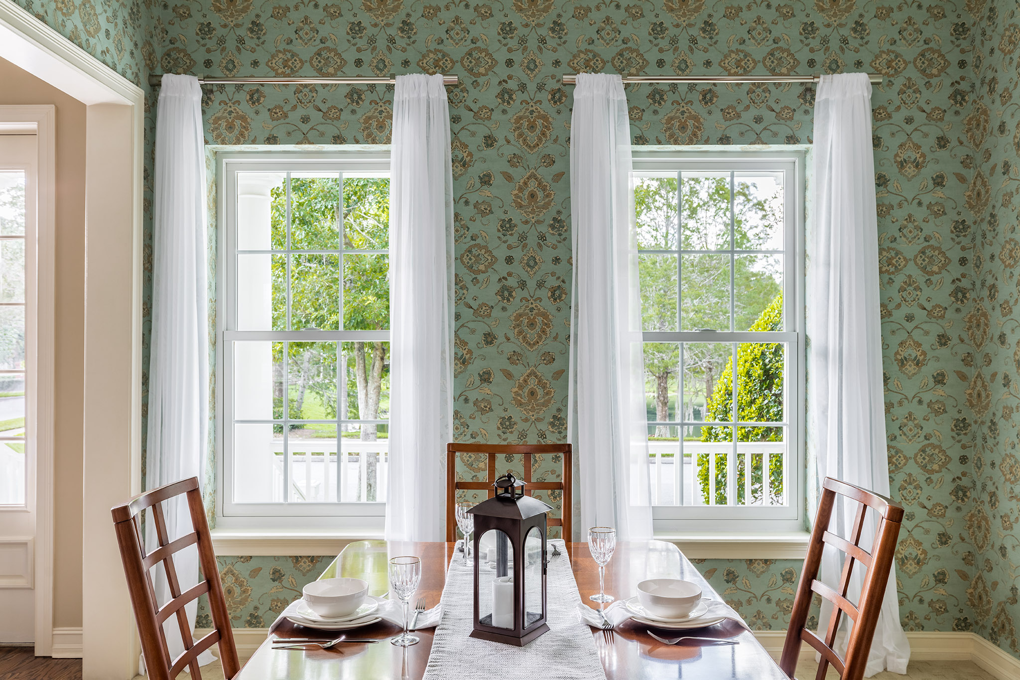 dining room with green wallpaper and white window frames