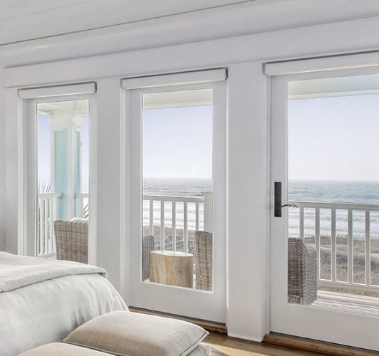 coastal bedroom with white windows and door set