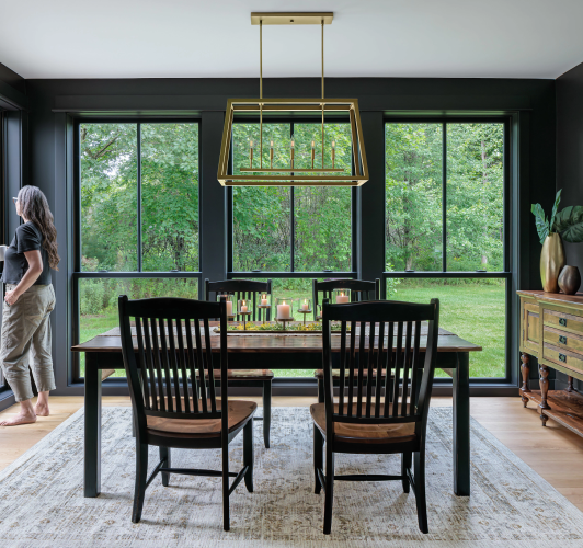 lady standing in dining room by floor to ceiling windows